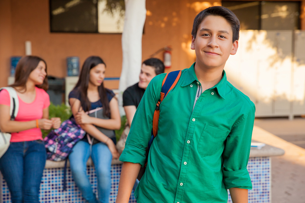 High school age students socializing and smiling