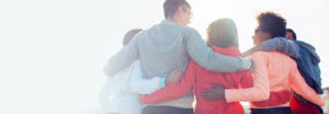 Group of five people in a semi-circle with arms interlocked