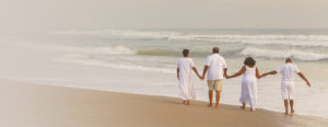 Family of four walking on the beach